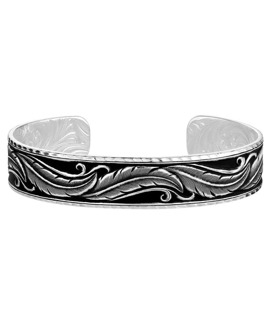 Side view of the women's silver tone cuff bracelet featuring the antiqued silver feather engravings on a black hand painted background