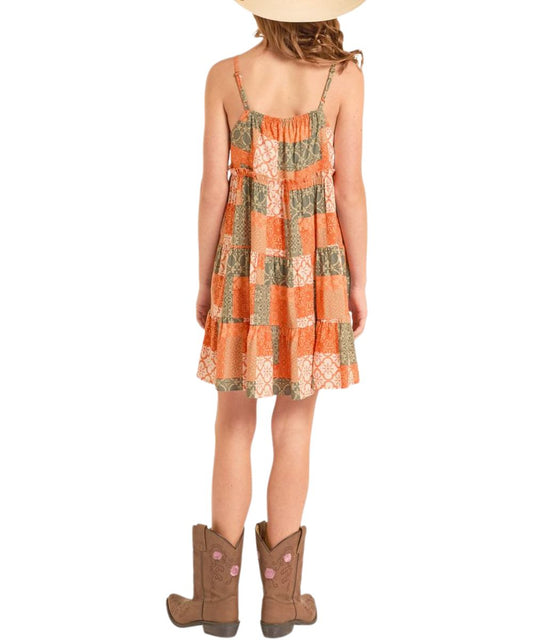 Girl's adjustable spaghetti strap dress falls just above the knee in a rust, orange, and green patchwork design.