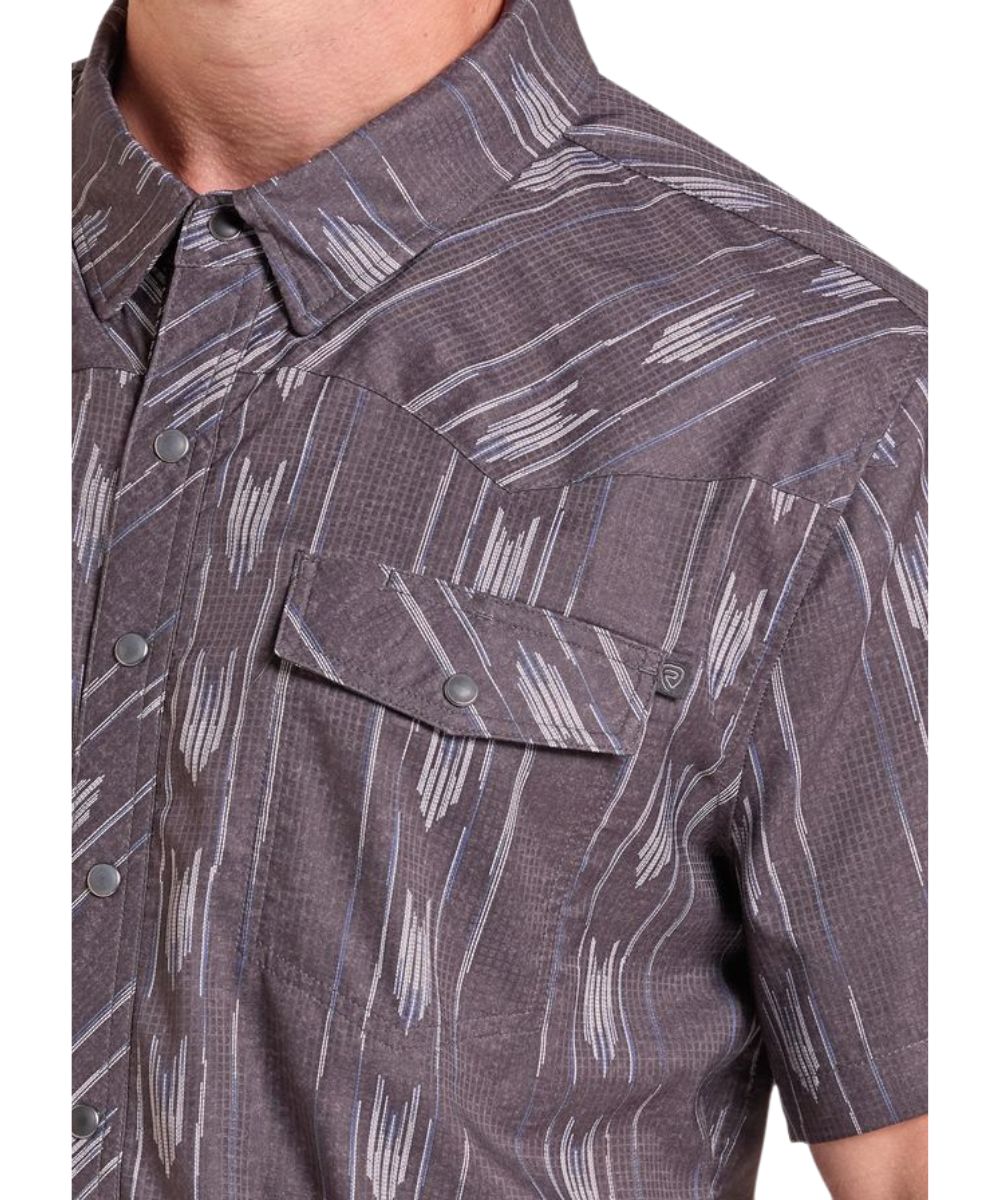 Close-up view of the black ikat striped print on the men's short sleeve shirt featuring the chest pockets, hidden snap down collar, and western yokes