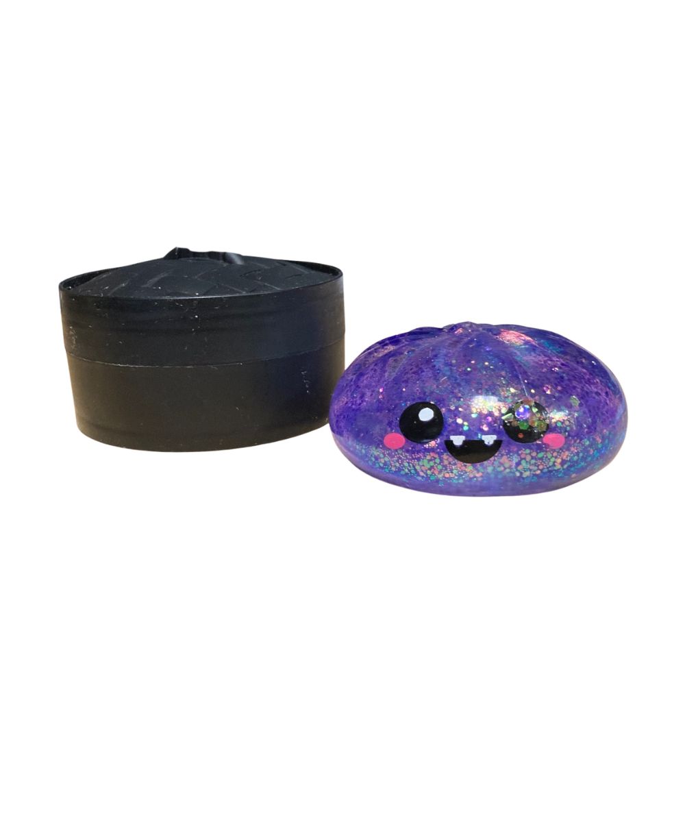 purple glitter squish toy with a fanged smile and dumpling storage case