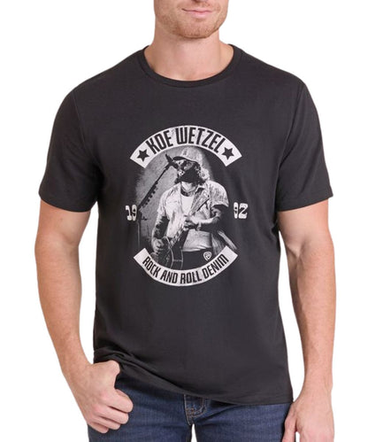Front view of a man modeling the Rock & Roll Denim Koe Wetzel Black Tee featuring the front screen-printed Koe Wetzel singing and playing guitar graphic
