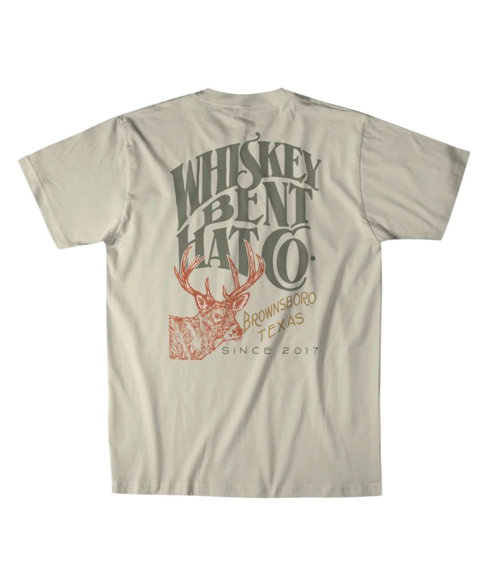 Back view of the men's natural Whiskey Bent Hat Co. short sleeve graphic tee featuring the large screen-printed logo with a buck deer graphic