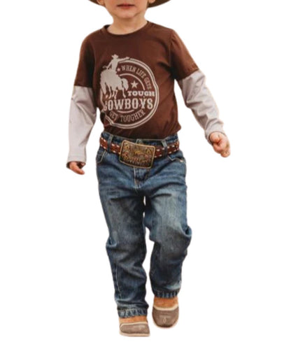 Model view of the toddler boy's brown long sleeve tee with a front screen print that reads: "when life gets tough cowboys get tougher" 