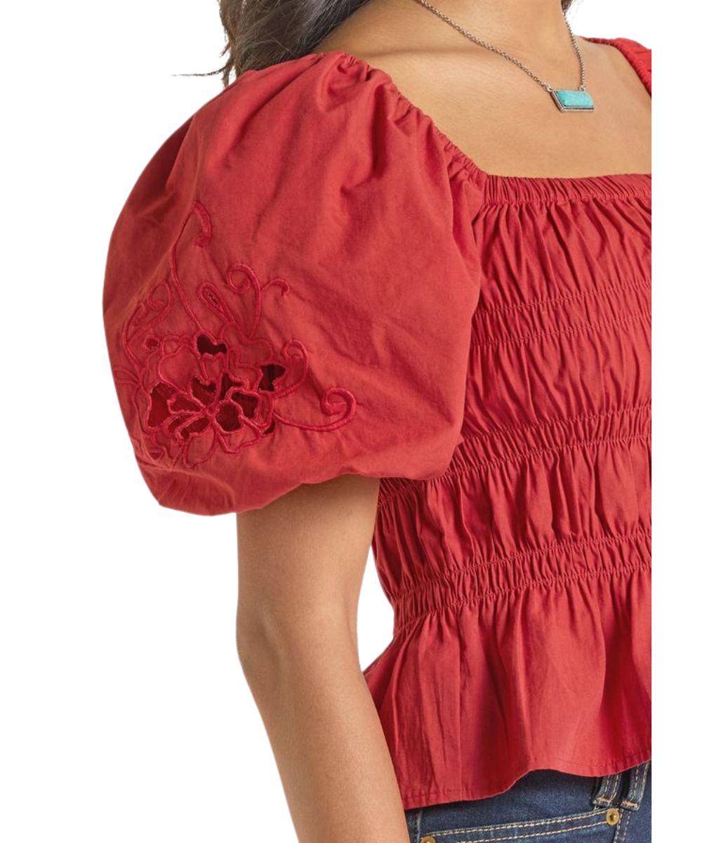 Close-up view of the women's red short balloon sleeve blouse with embroidered detailing on the sleeves