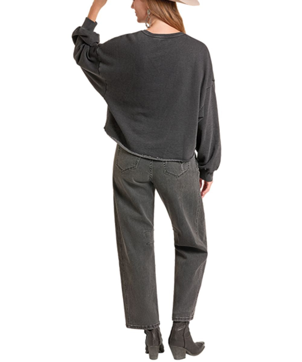 A woman shown from the back wearing a dark charcoal gray oversized long-sleeve sweatshirt, matching dark gray jeans, and black ankle boots against a plain white background.