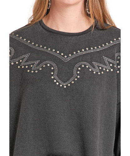 A close-up of a person wearing a dark charcoal gray crewneck sweatshirt with silver rhinestone western-style embroidery across the chest.