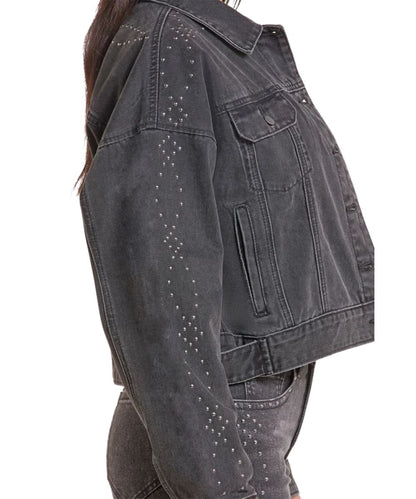 Side view of the women's black denim jacket featuring the welt hand pockets, spread collar, and studded sleeve details