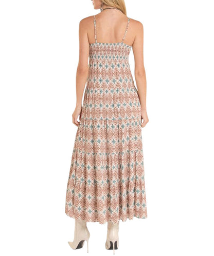 Back view of the women's rust ikat printed midi dress featuring adjustable spaghetti shoulder straps, smocked back, and a tiered skirt