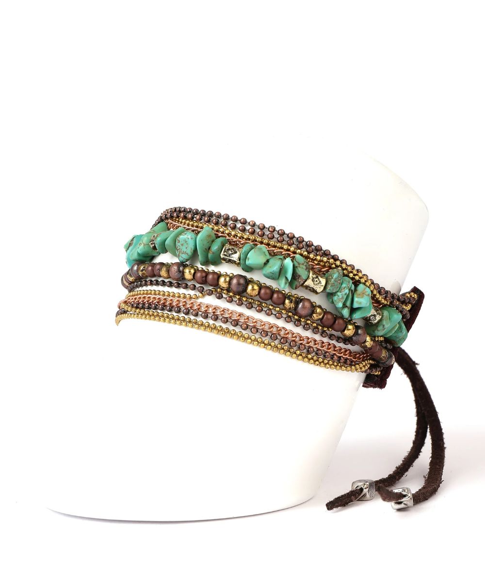 A multi-layered bohemian-style wrap bracelet displayed on a white mannequin stand. The bracelet features natural green stone beads, brown seed beads, and dark brown braided cord with silver-toned metal clasps.