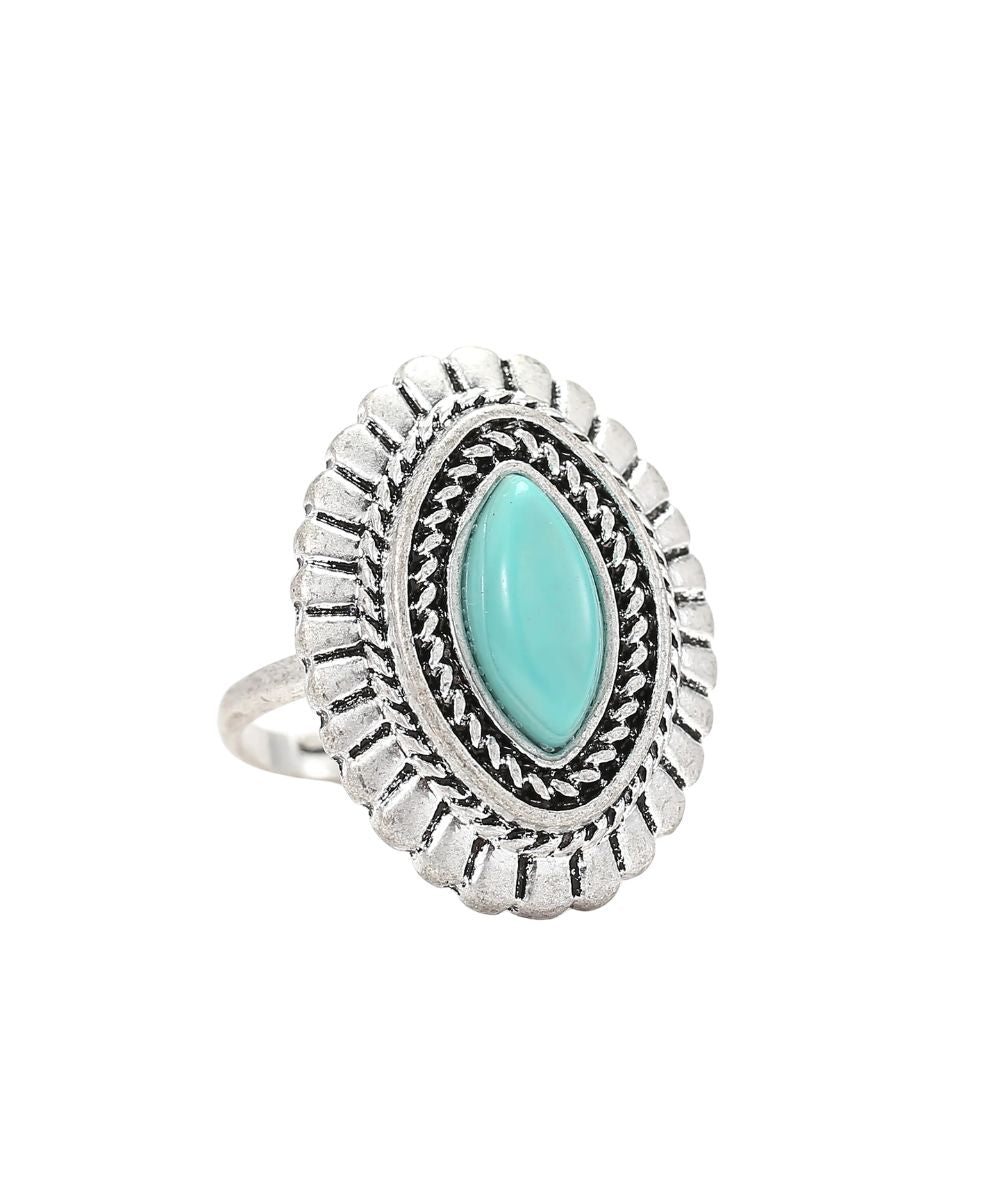 A silver-toned oval ring featuring a central marquise-cut light turquoise stone, surrounded by textured engraved detailing and a scalloped outer border, shown on a plain white background.