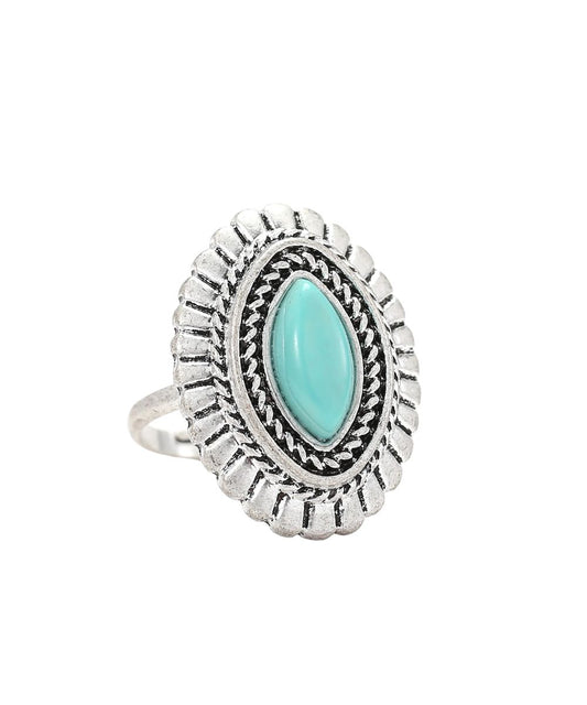 A silver-toned oval ring featuring a central marquise-cut light turquoise stone, surrounded by textured engraved detailing and a scalloped outer border, shown on a plain white background.