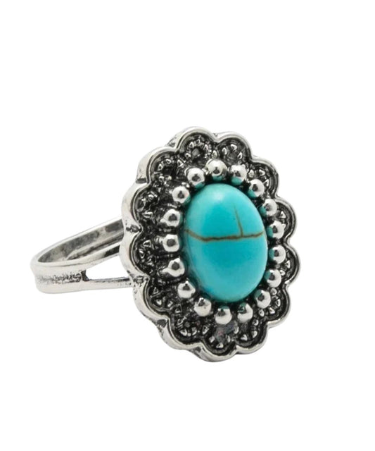 flower shaped silver toned ring with oval shaped turquoise stone center