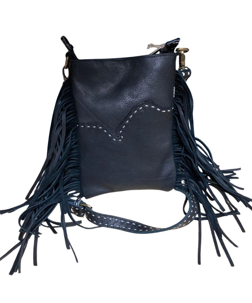Back view of the women's black leather crossbody featuring the fringe details, top zip closure, removable/adjustable crossbody strap, and contrast stitched accents