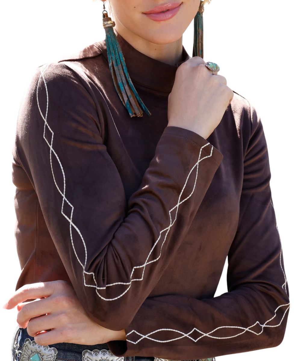 Close-up view of the contrast western embroidery accents on the sleeves of the women's brown faux suede mock neck top