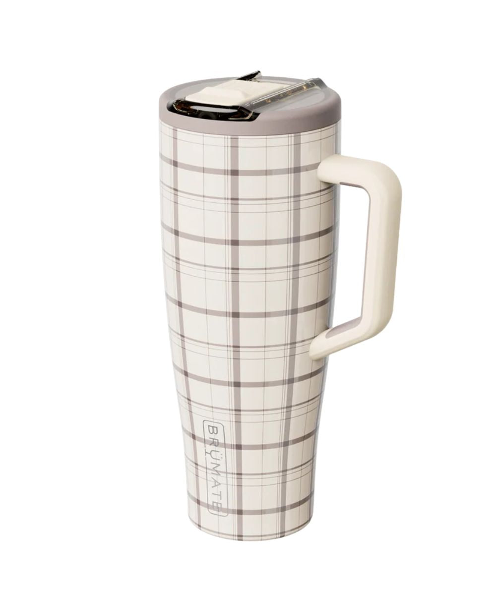 A tall travel tumbler with a cream and brown plaid pattern, featuring a matching cream handle and lid, shown on a plain white background.