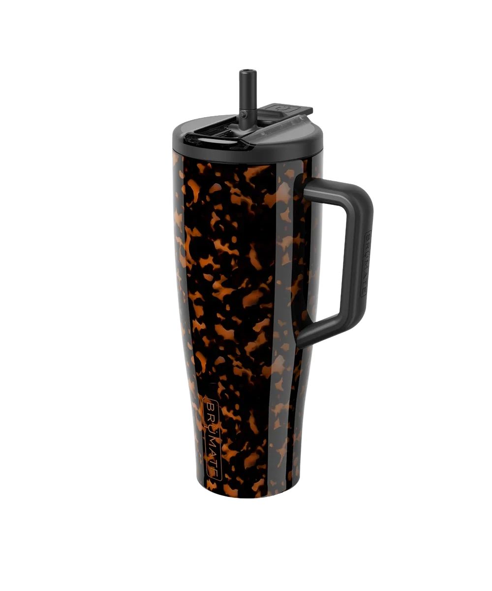 A tall travel tumbler with a black handle, black lid, and a glossy black and orange tortoiseshell pattern, shown on a solid white background.