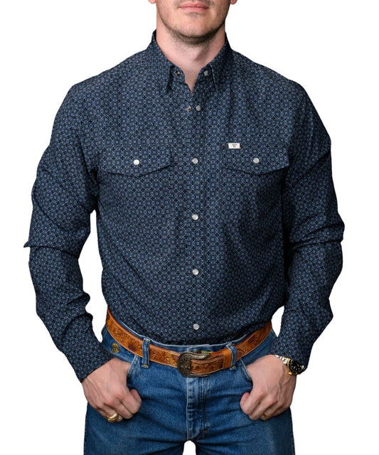Man wearing a men's black long sleeve pearl snap shirt with blue geometric print, front view