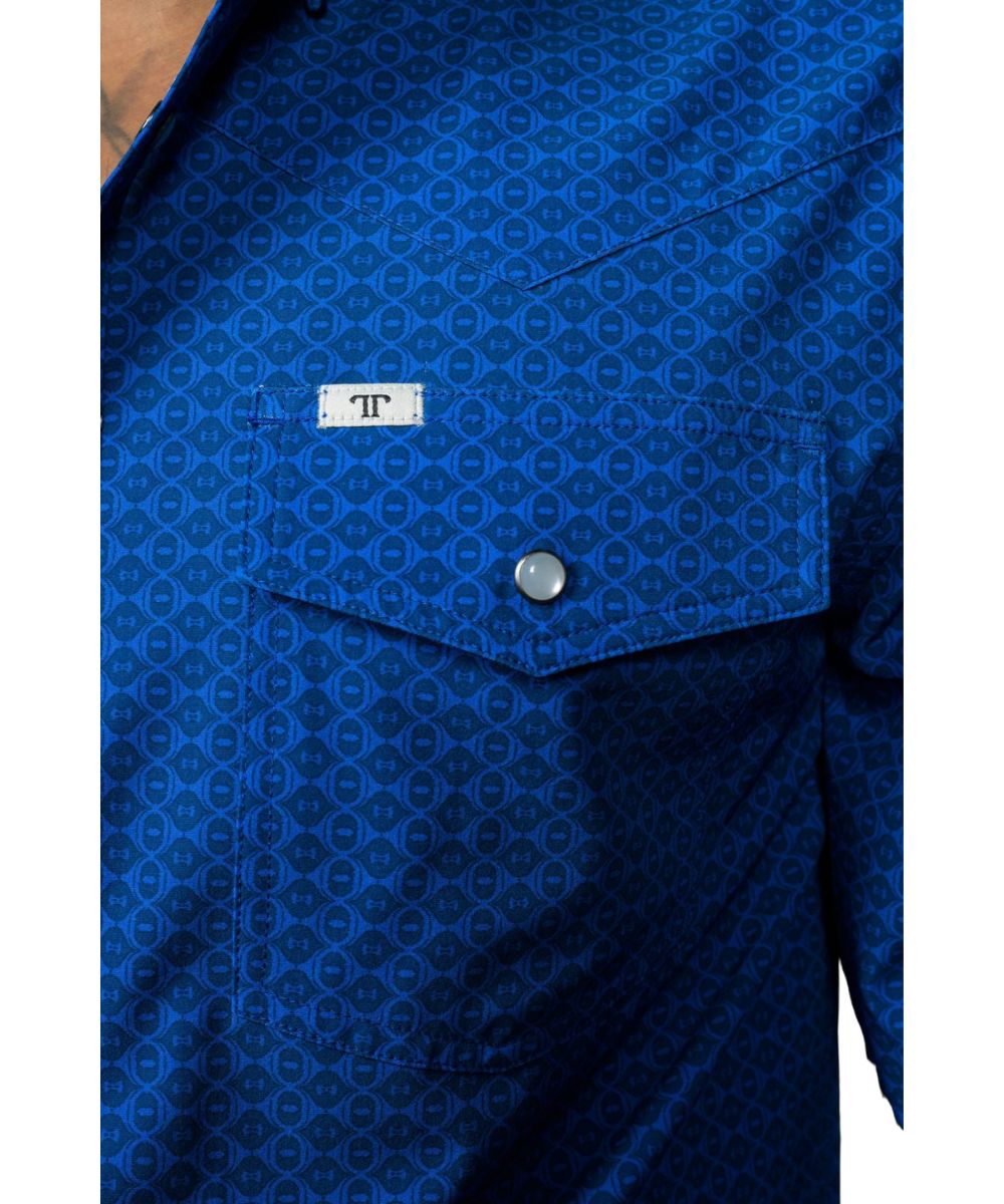 Close-up view of the single point snap flap chest pocket featuring the pen/sunglasses slot and geometric print