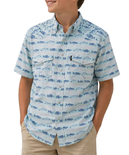 Front view of a boy modeling the short sleeve cloud blue snap shirt featuring pearl snaps, chest pockets, and lightweight moisture wicking poly-ripstop fabric