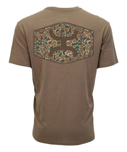 A brown short-sleeve t-shirt shown from the back, featuring a large hexagonal camouflage patch with a deer head silhouette in the center.