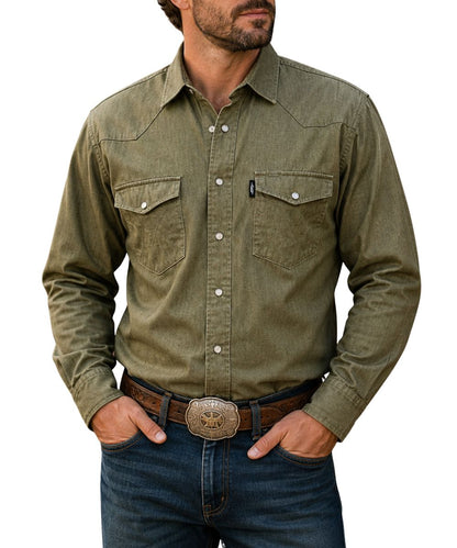 Model view of the men's long sleeve denim chambray dark olive green snap shirt featuring the pearl snaps, western yokes, and snap flap chest pockets