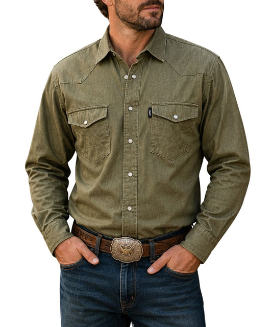 Model view of the men's long sleeve denim chambray dark olive green snap shirt featuring the pearl snaps, western yokes, and snap flap chest pockets