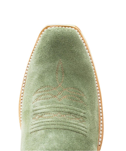 Close-up of a sage green suede boot toe with decorative stitching and a light tan sole edge on a white background.