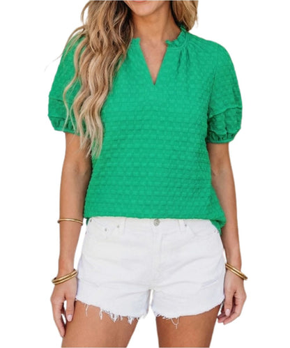 Front view of the women's short sleeve blouse featuring puffed sleeves, a v-neckline, and a textured body