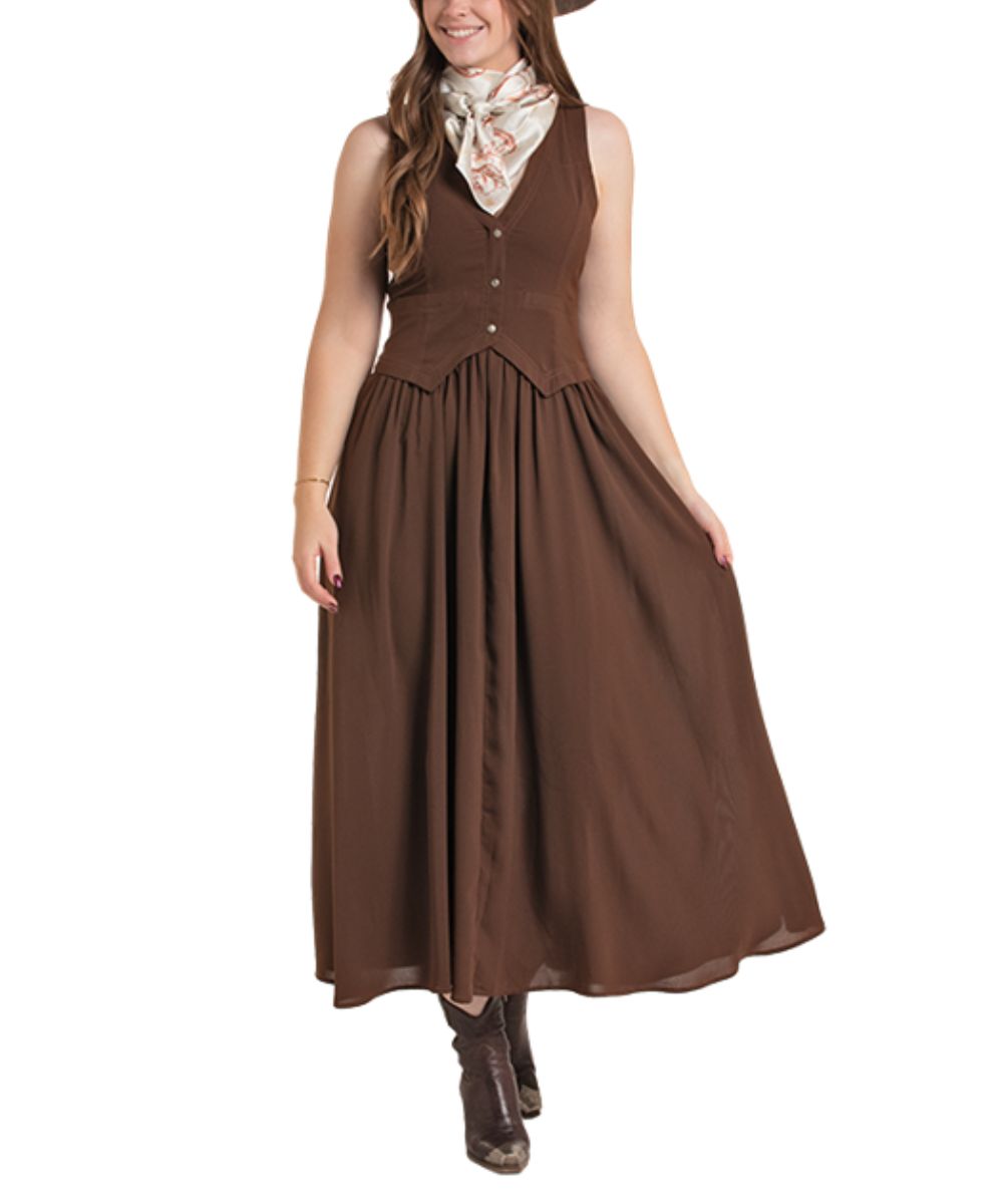 A woman models a sleeveless brown vest dress styled with a patterned neck scarf and brown boots against a plain white background.