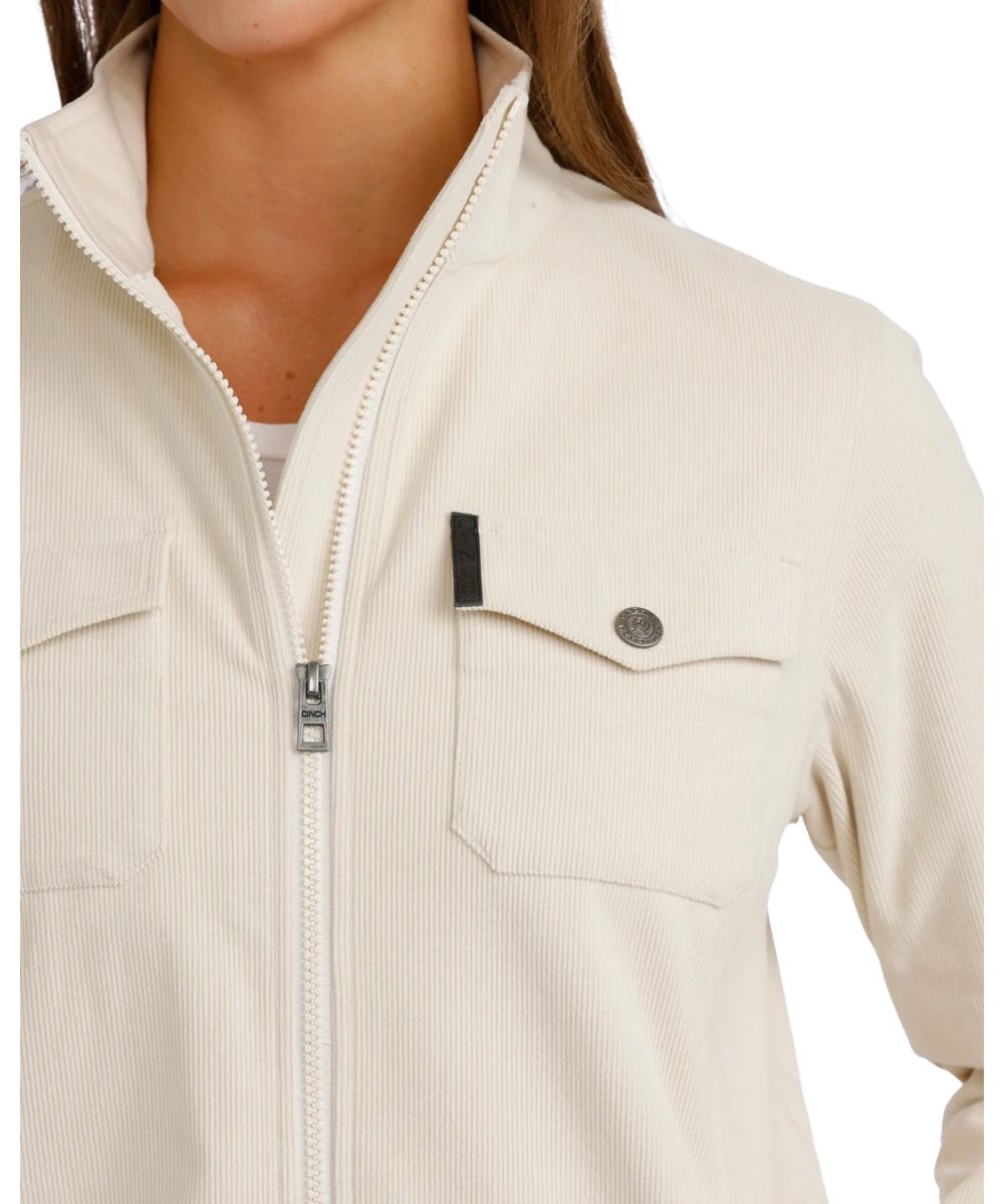 Close-up view of the single point snap flap chest pocket with a logo label featuring the solid cream corduroy knit print