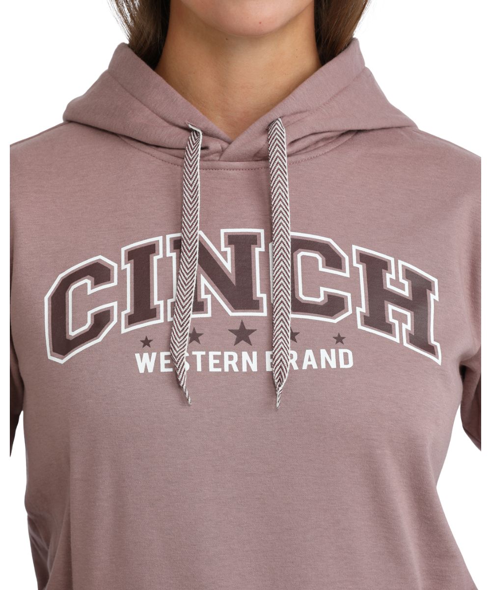Close-up view of the logo screen printed on front chest that reads: "Cinch Western Brand" featuring the contrast drawcord on the women's lilac hoodie
