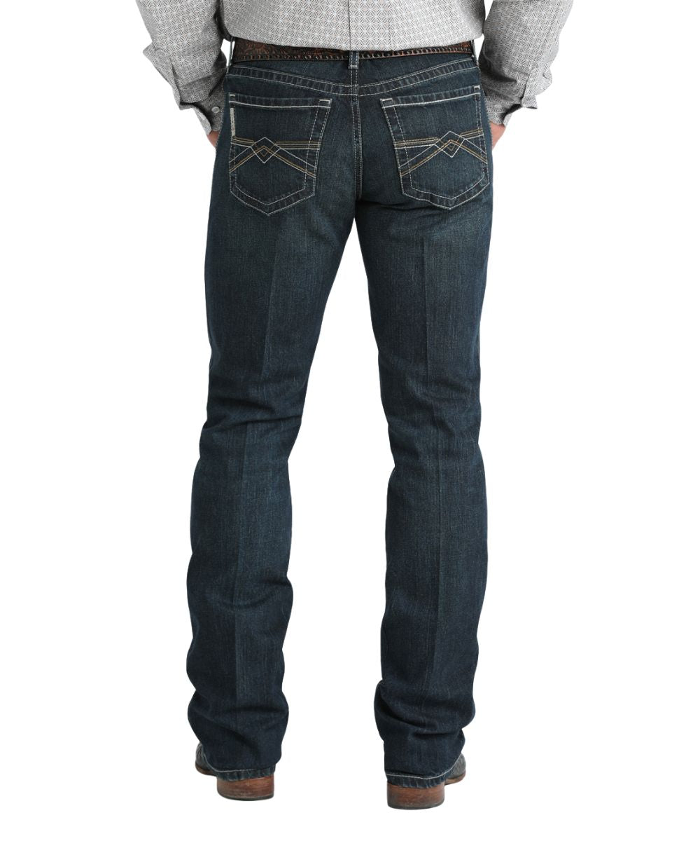 Back view of the men's slim fit dark stonewash ian jean featuring the boot cut leg and cream and brown stitching