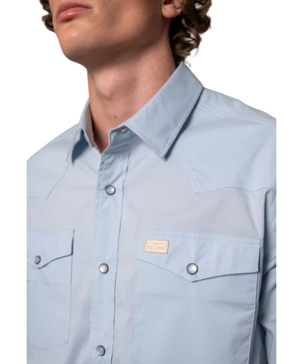 Close-Up View Of The Men's Light Blue Western Snap Shirt Featuring The Pearl Snaps, Western Yokes, And Chest Pockets