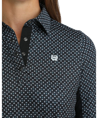 Close-up view of the white geometric print, black knit panels, 1/4 pearl snap placket, and spread collar