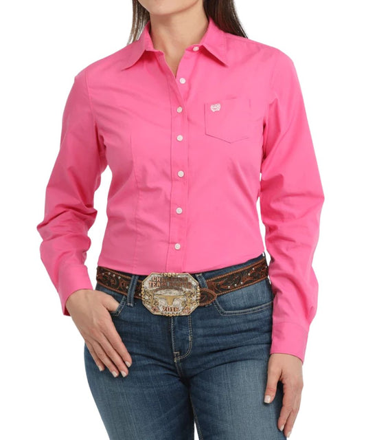 Front view of the women's arena fit long sleeve solid print pink button down western shirt featuring the single open chest pocket 