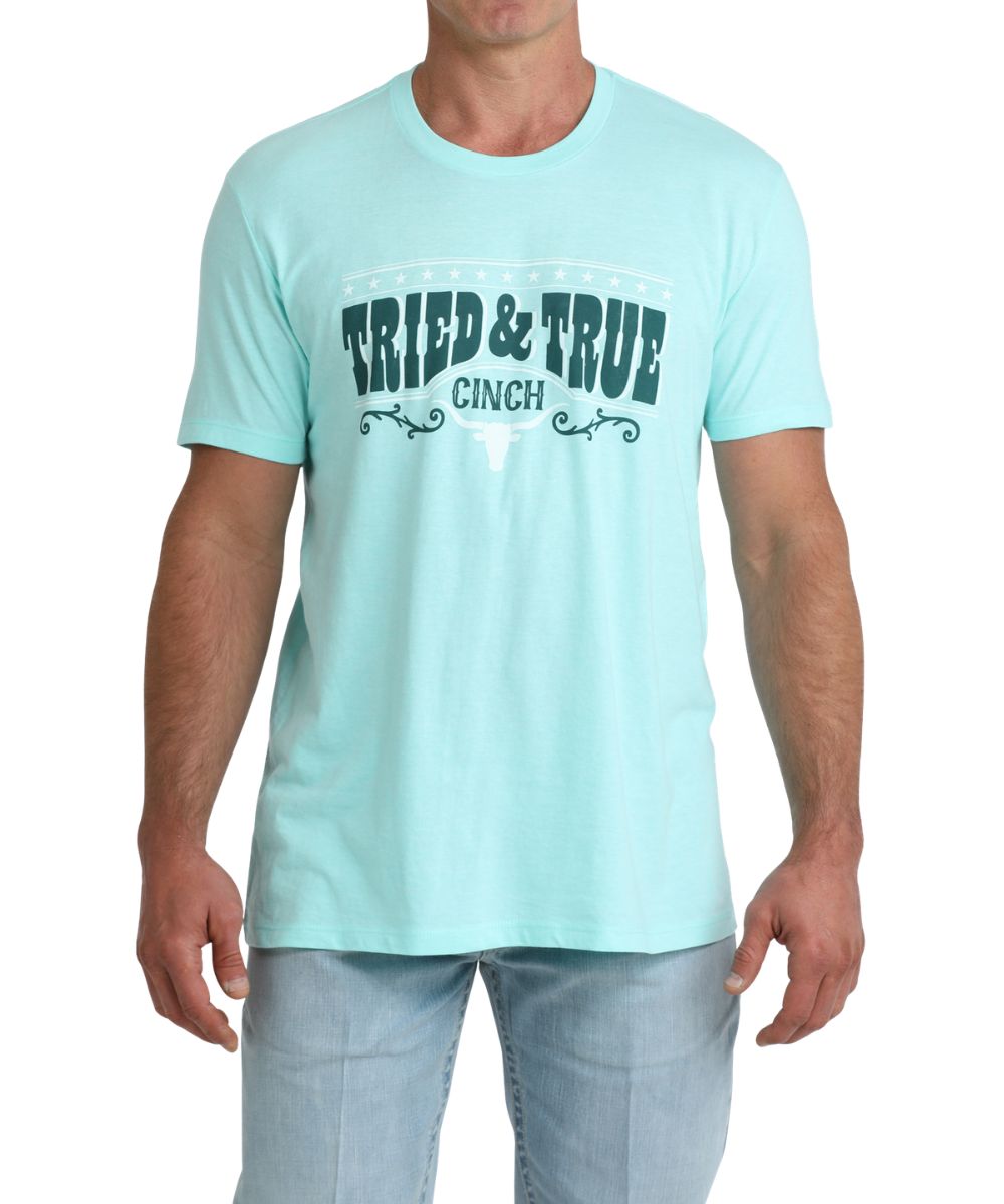 Front view of the men's turquoise graphic tee featuring a front screen print that reads: "Tried & True"
