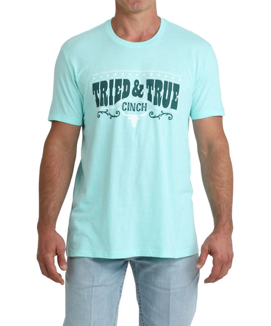 Front view of the men's turquoise graphic tee featuring a front screen print that reads: "Tried & True"