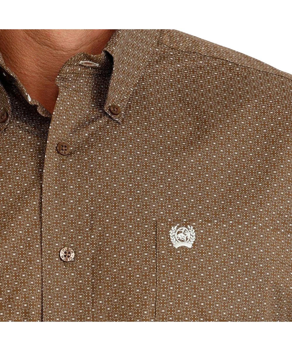 Close-up view of the white geometric print, brown buttons, and single open chest pocket with logo embroidery