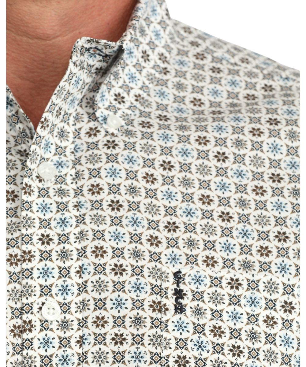 Close-up view of the geometric print, cream buttons, and chest pocket with logo embroidery