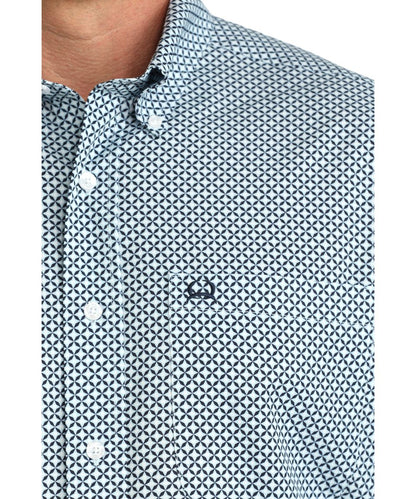 Close-up view of the white geometric print, single open chest pocket, and button down collar