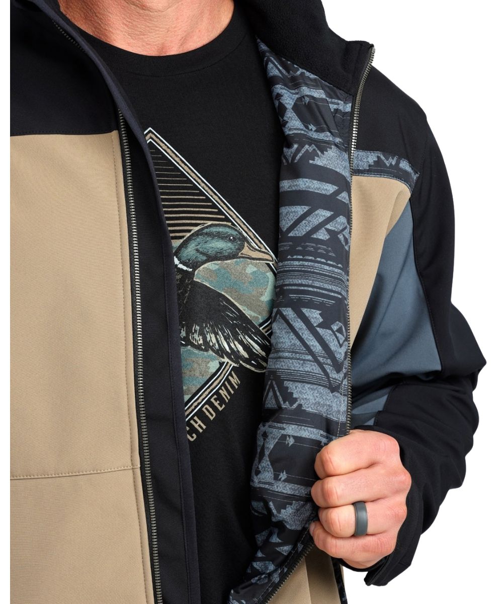 Close-up view of the contrast interior lining on the men's tan & black jacket featuring the tan color blocked body with black & gray sleeves, and southwestern trim accents