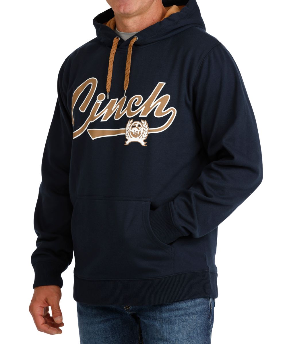 Side view of the men's navy logo hoodie featuring the front kangaroo pocket, contrast hood lining, rib knit trim, and a contrast adjustable hood drawstring