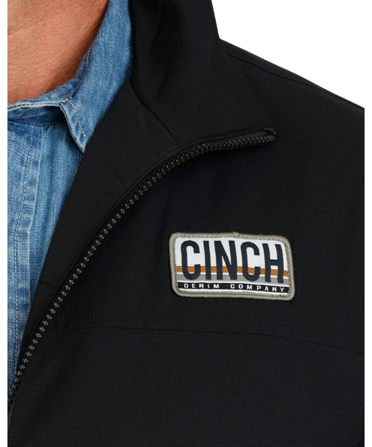 Close-up view of the men's lightweight black Cinch Vest featuring the durable water-resistant finish and the woven logo label at the left chest