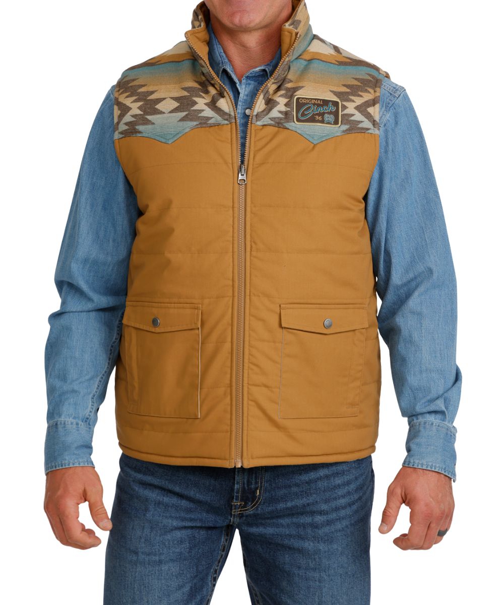 Front view of the men's tan Cinch Reversible Vest featuring the color blocked design (with blue serape yokes), western yokes, snap flap hand pockets, mock collar, and zip closure