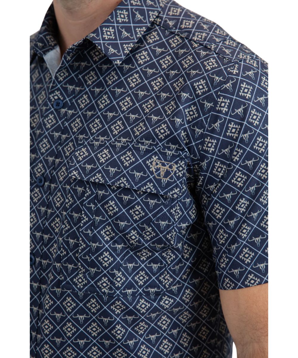 Close-up view of the blue button down with a tan longhorn geometric print featuring flap chest pockets.