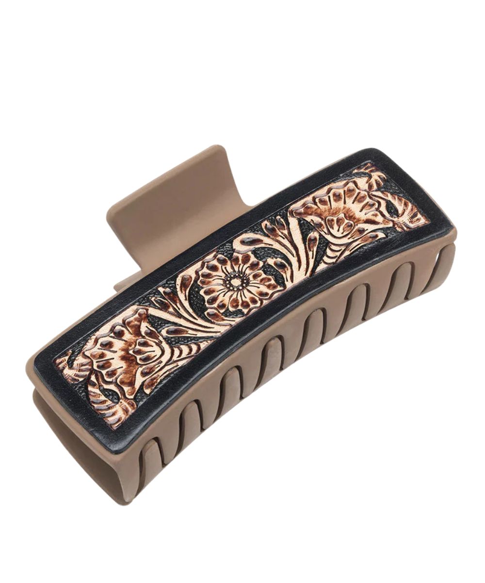Women's sandstone plastic claw clip with floral tooled leather overlays.