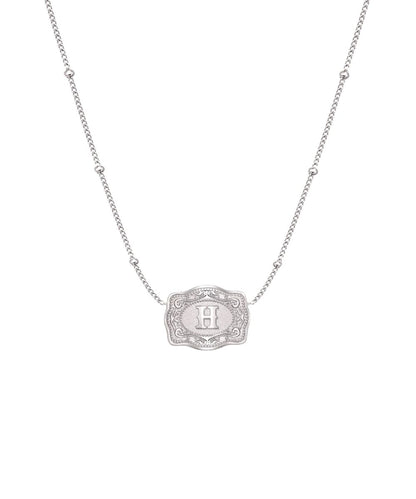 ultra mini silver belt buckle h initial necklace on white background