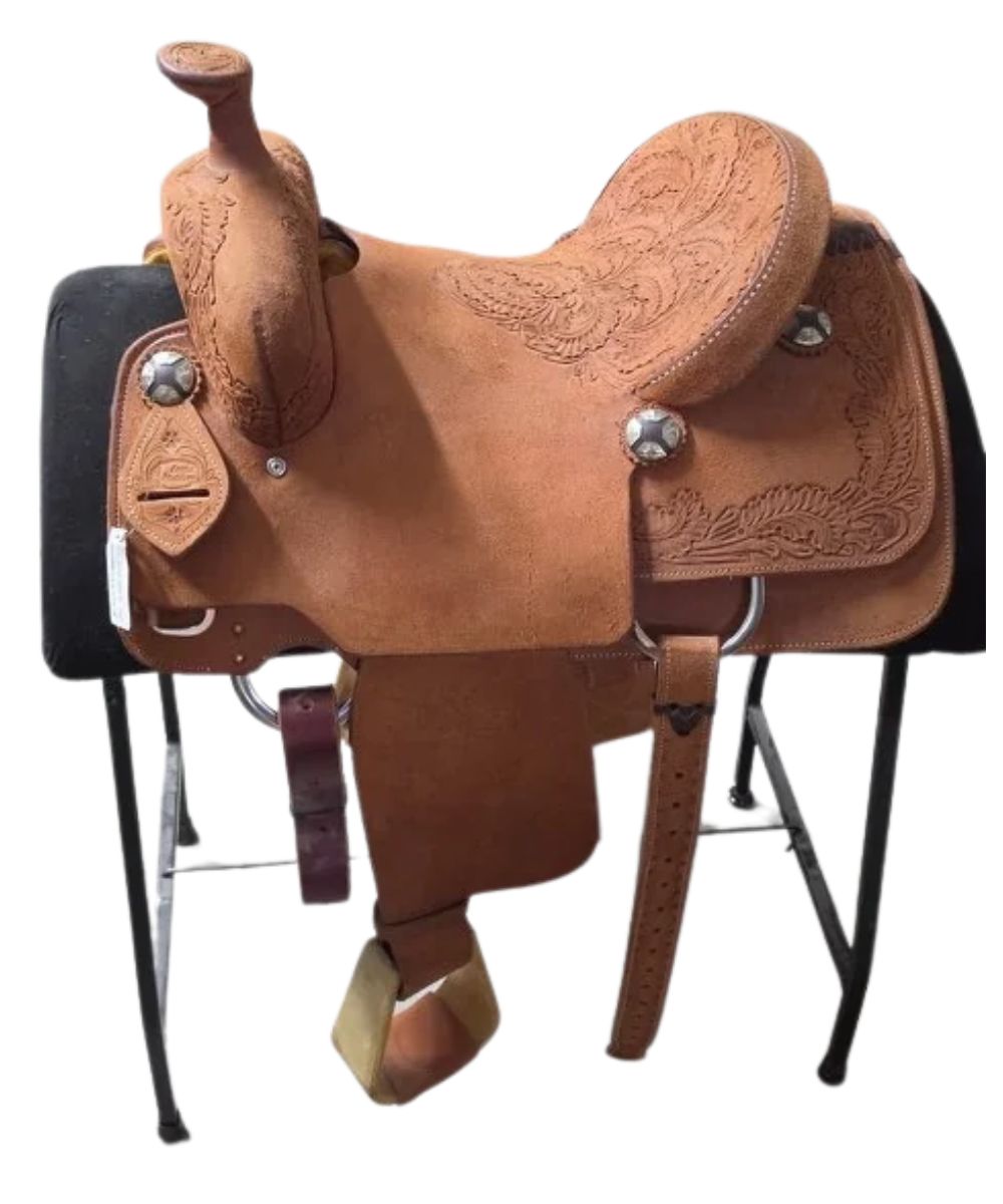 A brown tooled leather western saddle displayed on a black stand against a white background.