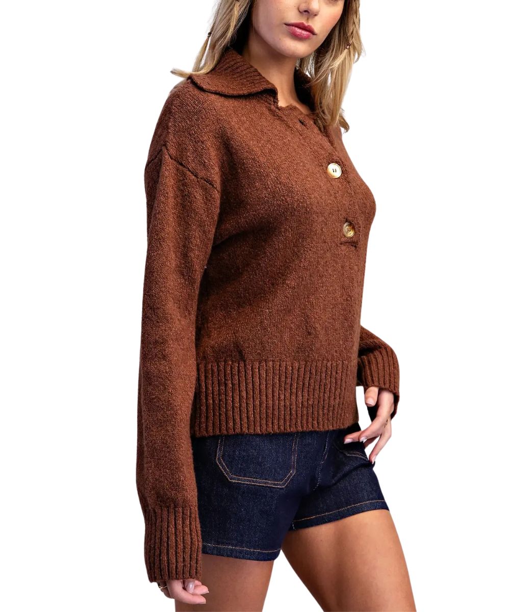 A woman wearing a brown knit button-front cardigan sweater with a collar and dark denim shorts, shown against a plain white background.