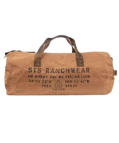 Front view of the tan canvas STS Ranch Surplus Duffle Bag featuring the genuine leather trim, an assorted STS Ranchwear print, a side leather carry handle, and the top leather carry handles
